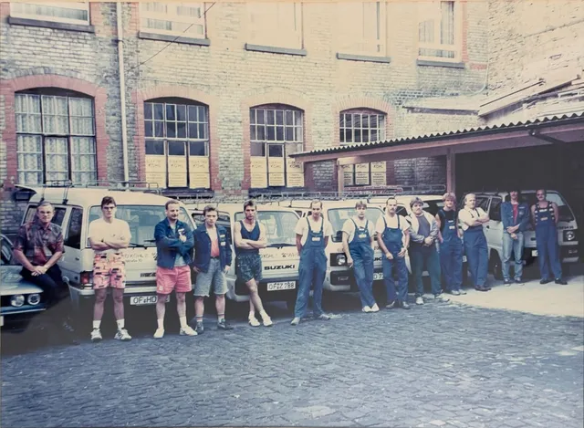 Das Team von Elektro Köhl mit Fahrzeugen vor dem Betriebsgebäude