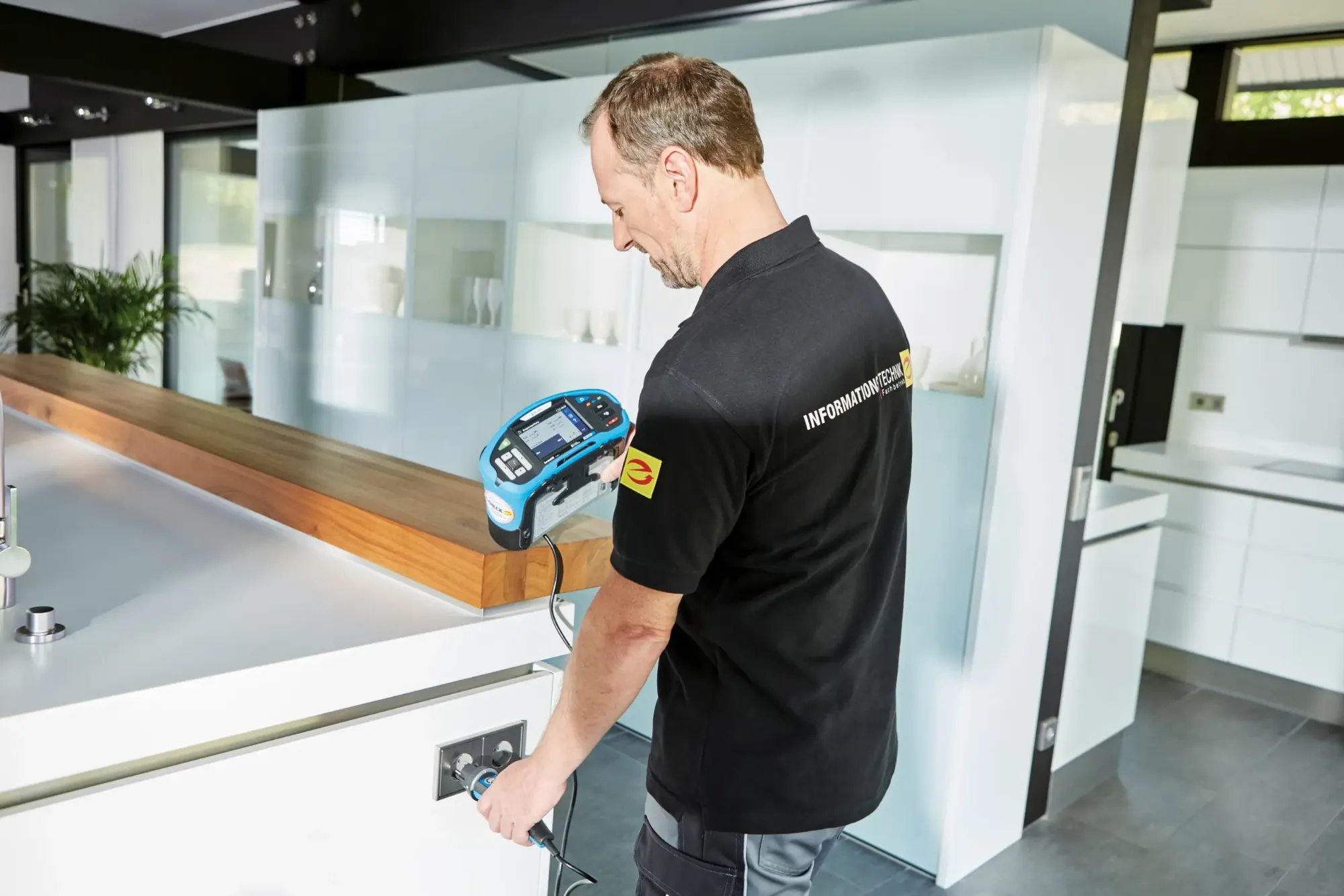 Elektro-Fachkraft prüft mit einem Messgerät eine Steckdose